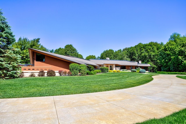 view of front of home with a front yard and concrete driveway