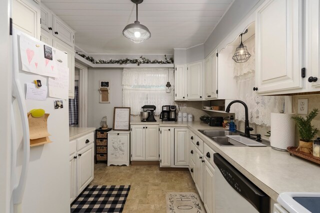 kitchen with white appliances, white cabinets, light countertops, and a sink