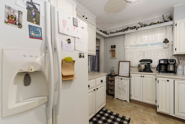 kitchen featuring white cabinets, light countertops, and white fridge with ice dispenser