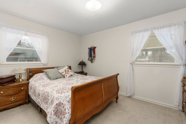 bedroom featuring baseboards and light colored carpet