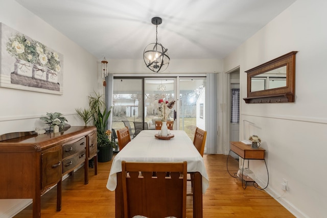 dining room with a notable chandelier and light wood-style flooring