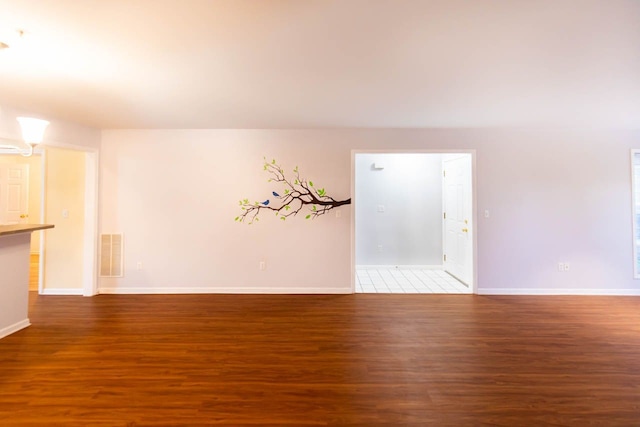 empty room featuring visible vents, baseboards, and wood finished floors