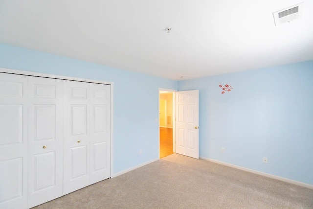 unfurnished bedroom with baseboards, visible vents, a closet, and carpet floors