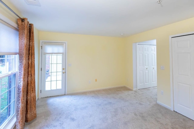 unfurnished room with light colored carpet and baseboards