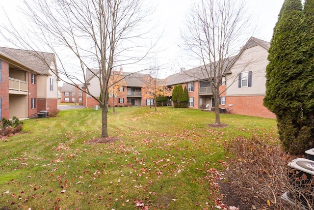 view of yard with central AC unit and a residential view