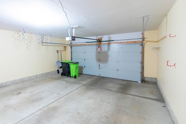 garage featuring a garage door opener and baseboards