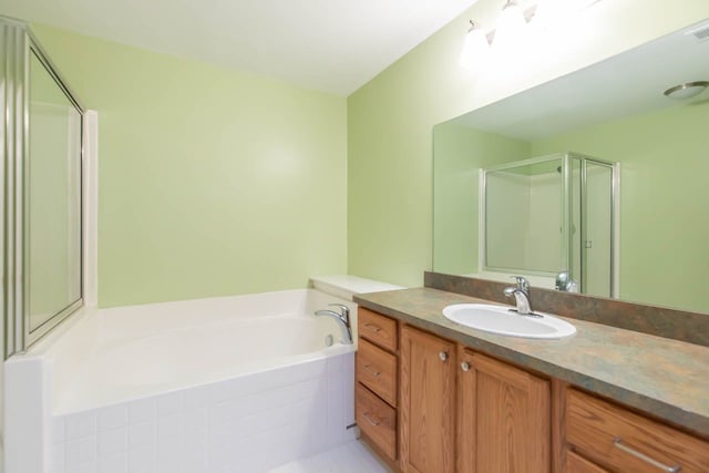 full bathroom featuring vanity, a shower stall, a bath, and visible vents