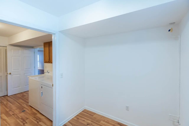 empty room with baseboards, light wood-style floors, and independent washer and dryer