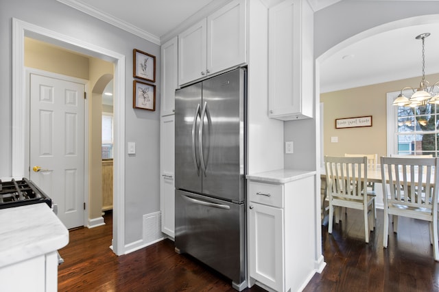 kitchen featuring stainless steel fridge, visible vents, arched walkways, white cabinets, and crown molding