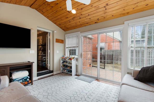 living area featuring lofted ceiling, wood ceiling, baseboards, and ceiling fan