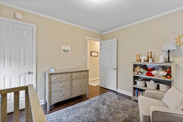 bedroom featuring baseboards, dark wood finished floors, and crown molding