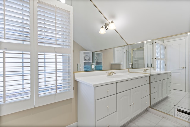 bathroom with lofted ceiling, a sink, a shower stall, and double vanity