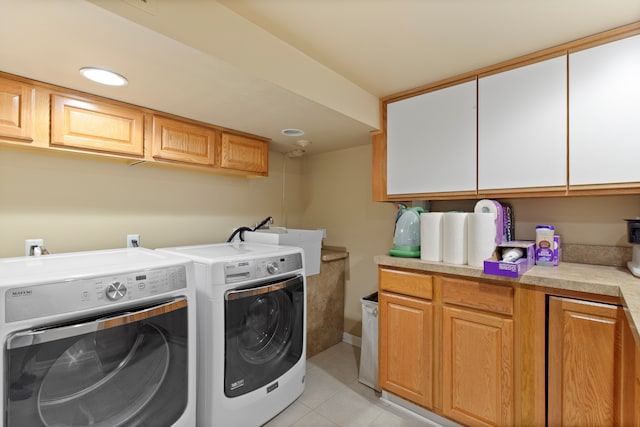 laundry room with light tile patterned floors, a sink, washing machine and clothes dryer, and cabinet space