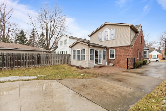 back of property with brick siding and fence