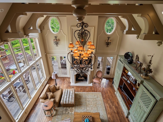 living area with high vaulted ceiling, french doors, and wood finished floors