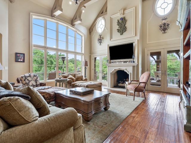 living room with beam ceiling, a premium fireplace, high vaulted ceiling, and hardwood / wood-style floors