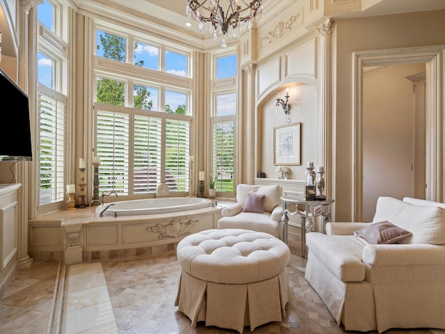 full bathroom featuring a garden tub, a high ceiling, crown molding, and an inviting chandelier