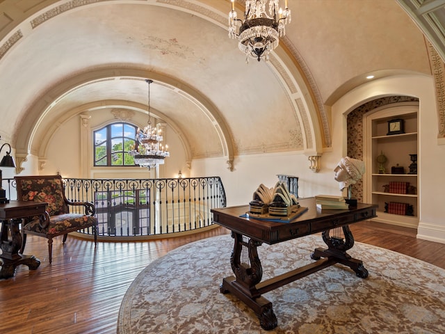 interior space featuring high vaulted ceiling, a notable chandelier, baseboards, built in features, and hardwood / wood-style floors