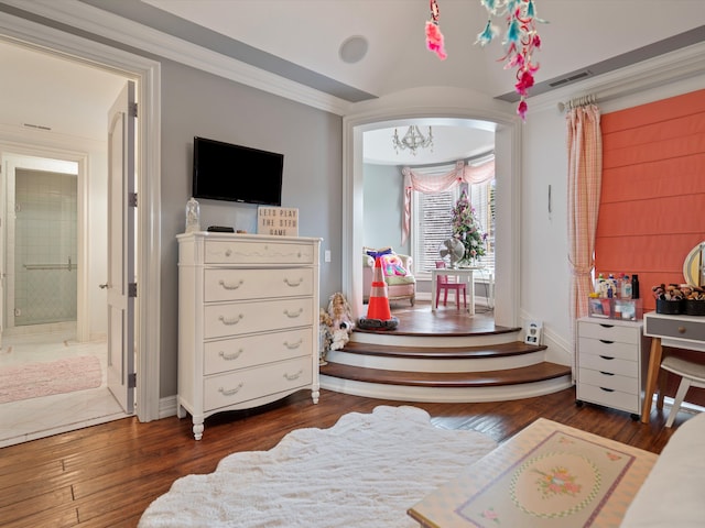 bedroom featuring wood-type flooring, visible vents, ornamental molding, connected bathroom, and baseboards