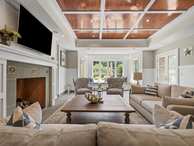 living room featuring ornamental molding, wood ceiling, and a wainscoted wall