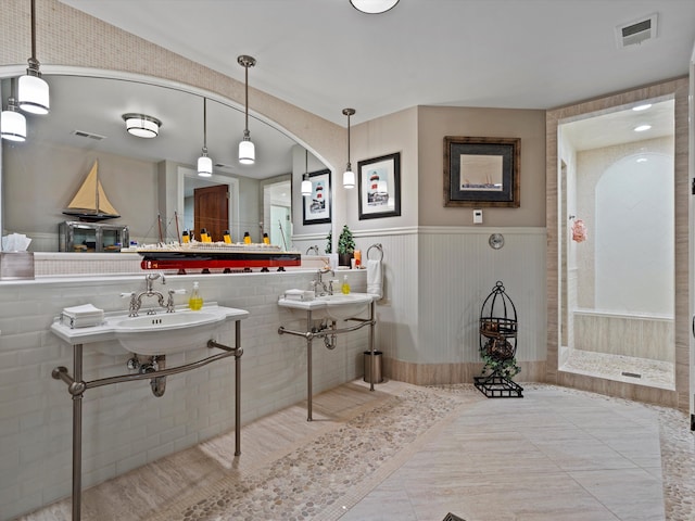 full bathroom featuring a wainscoted wall, a sink, visible vents, and tile patterned floors