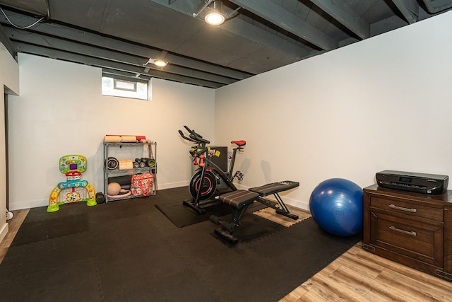 exercise area featuring light wood finished floors and baseboards