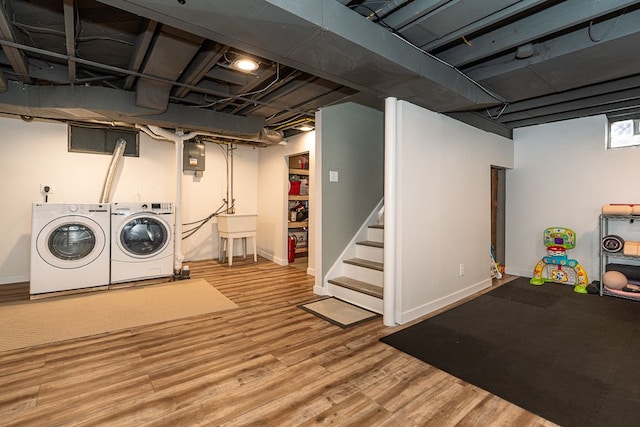 finished basement with electric panel, baseboards, wood finished floors, independent washer and dryer, and stairs