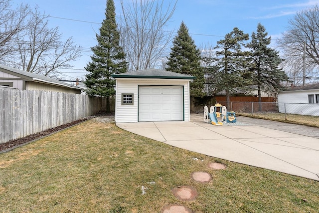 detached garage featuring concrete driveway and fence