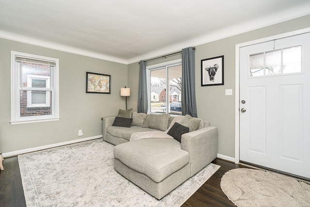 living room featuring crown molding, dark wood-style flooring, and baseboards