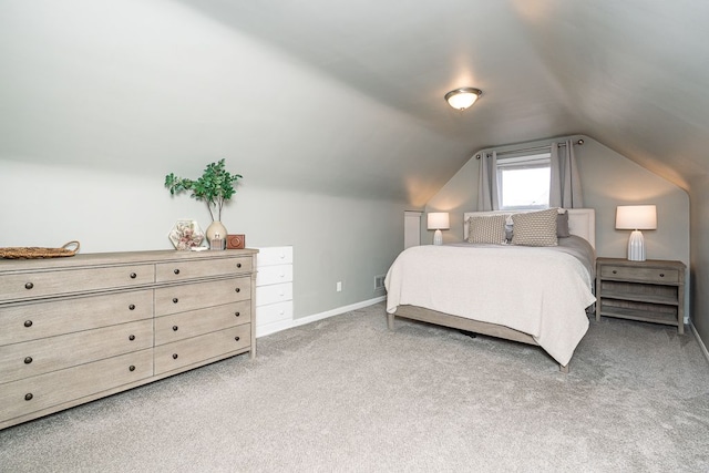 carpeted bedroom featuring lofted ceiling and baseboards