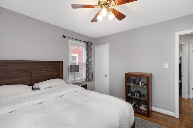 bedroom featuring ceiling fan, baseboards, and wood finished floors