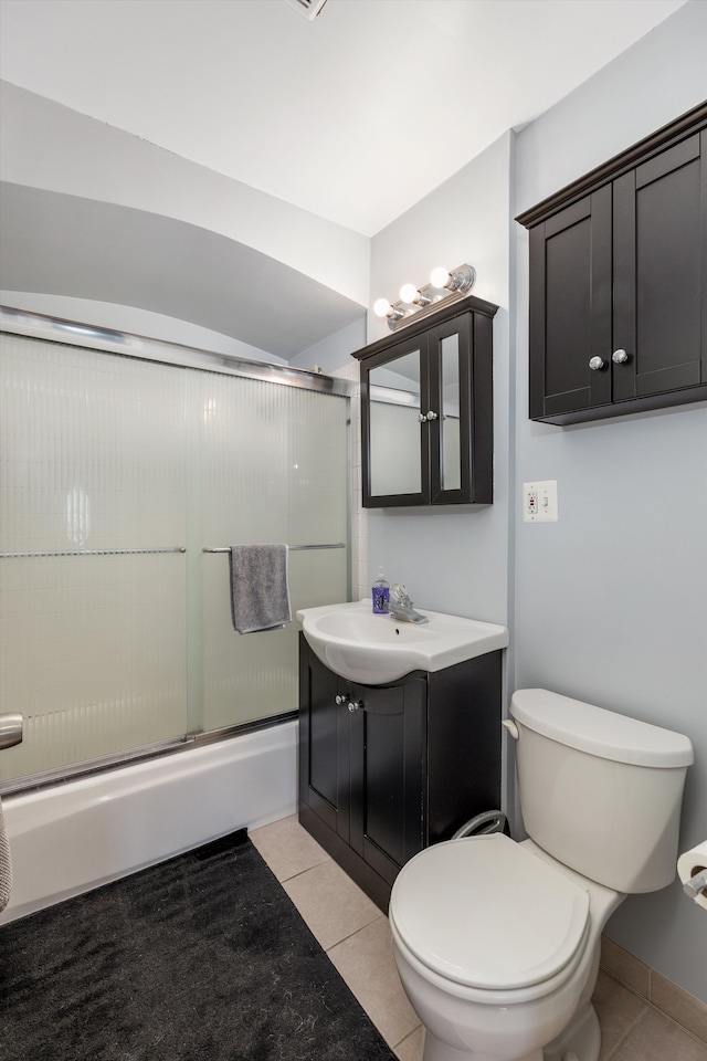 bathroom with baseboards, toilet, tile patterned flooring, combined bath / shower with glass door, and vanity