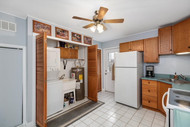 kitchen featuring white appliances, stacked washer / dryer, a sink, and brown cabinets