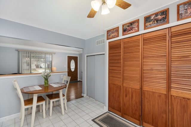 interior space featuring light tile patterned floors, baseboards, visible vents, and a ceiling fan