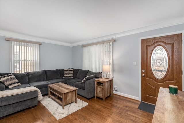 living room featuring baseboards, ornamental molding, and wood finished floors