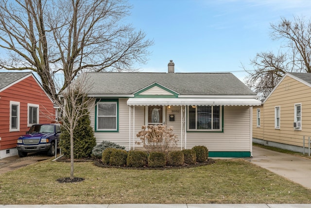 bungalow-style house with a shingled roof, a chimney, and a front yard