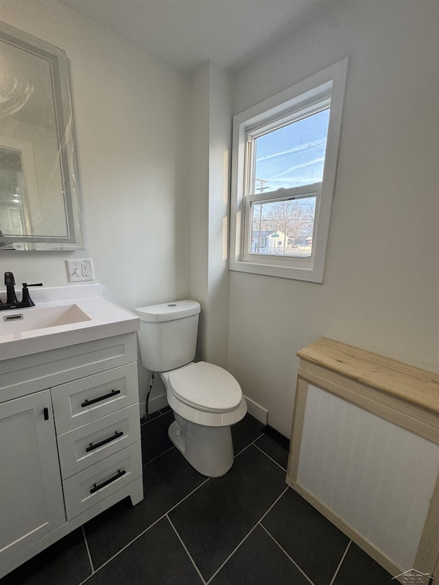 bathroom with baseboards, vanity, toilet, and tile patterned floors