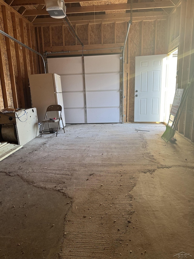 garage with freestanding refrigerator and a garage door opener