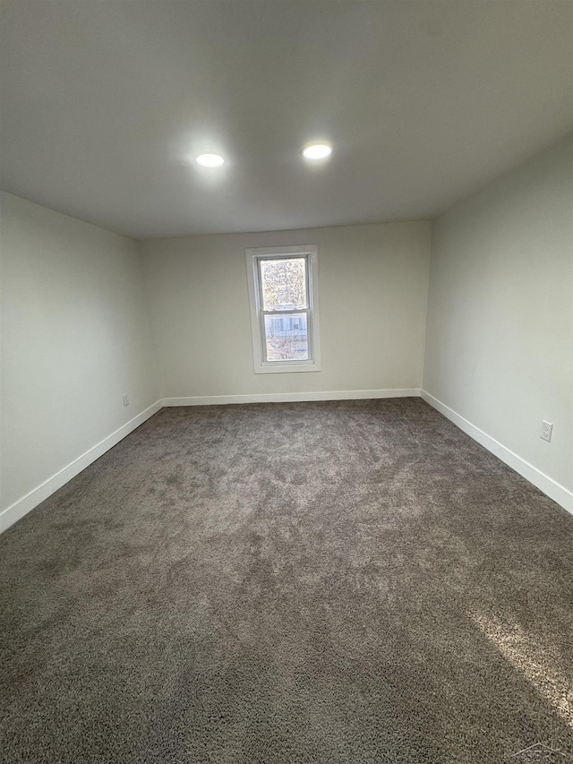 empty room featuring baseboards, dark colored carpet, and recessed lighting