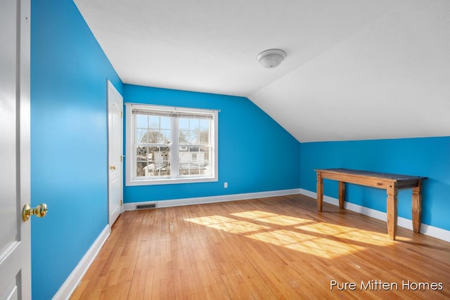 bonus room with lofted ceiling, wood-type flooring, visible vents, and baseboards