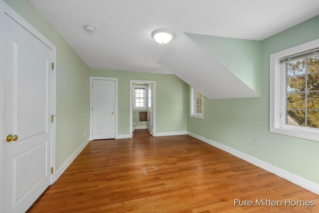 bonus room with vaulted ceiling, wood finished floors, and baseboards