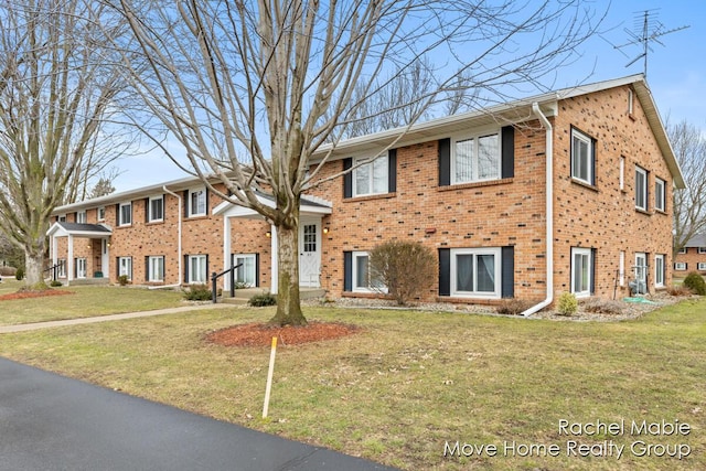 view of front of home with a front yard and brick siding