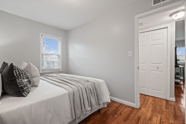 bedroom featuring visible vents, baseboards, and wood finished floors