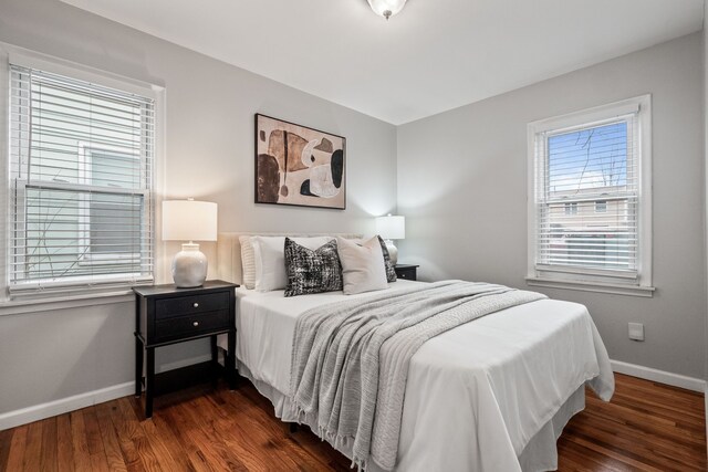 bedroom with dark wood-style floors and baseboards