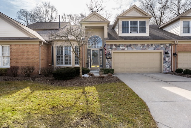 traditional-style home featuring an attached garage, brick siding, stone siding, driveway, and a front lawn