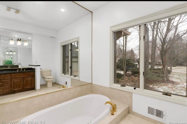 full bathroom with a tub to relax in, toilet, vanity, visible vents, and tile patterned floors