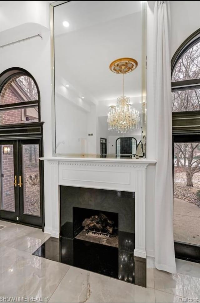 interior space featuring a chandelier, french doors, and a fireplace