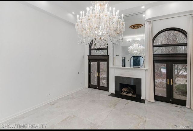 unfurnished living room featuring a fireplace with flush hearth, a high ceiling, baseboards, and french doors