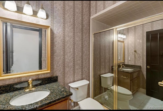 full bath featuring wallpapered walls, a stall shower, toilet, tile patterned floors, and vanity