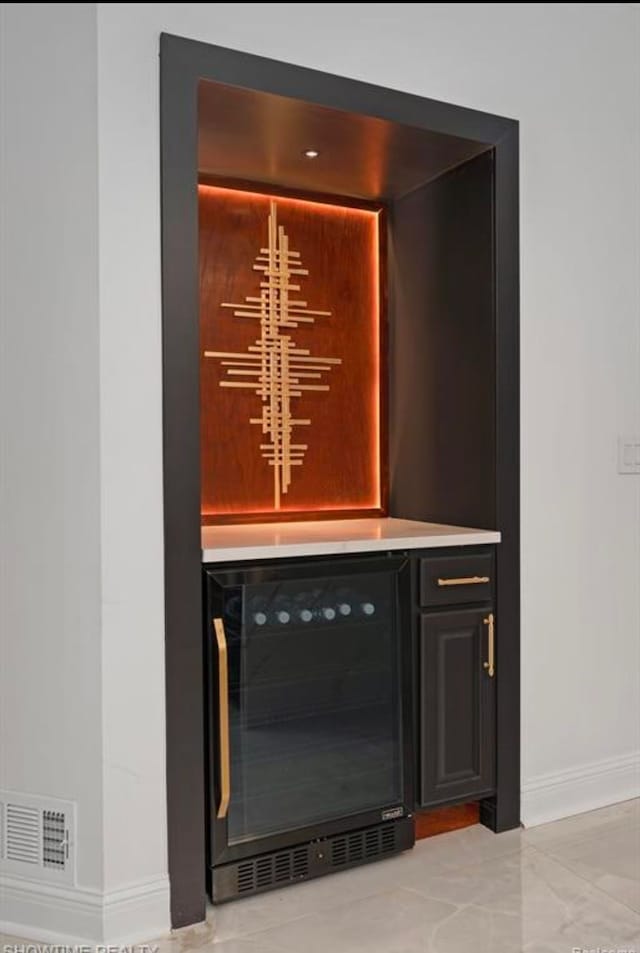 bar featuring wine cooler, visible vents, and baseboards